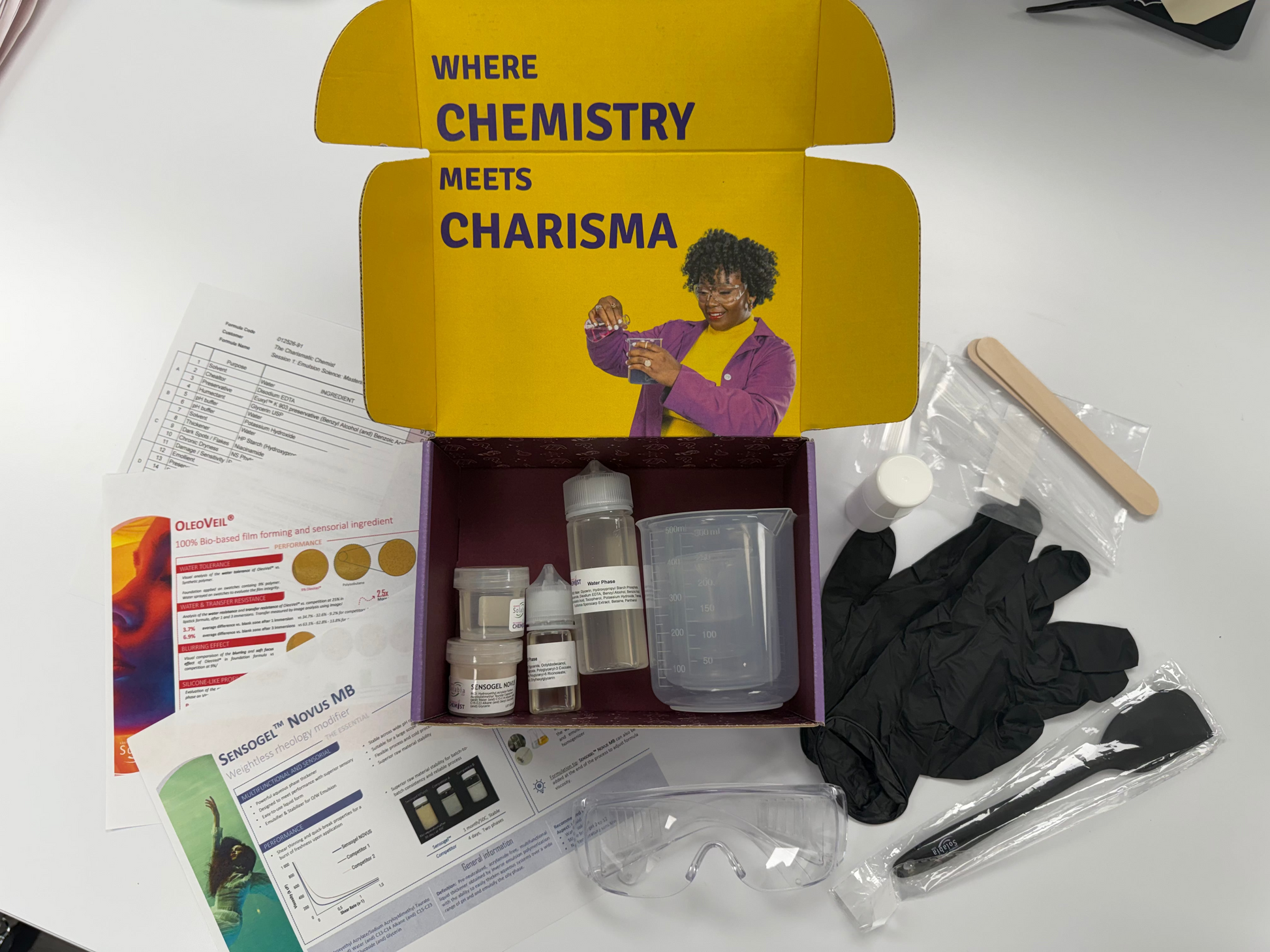 The Charismatic Chemist Custom Yellow box labeled 'CHARISMA MEETS CHEMISTRY' with lab supplies on a white surface